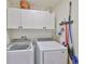 Neat laundry room with white cabinets, washer, and dryer at 16704 Sunburst Lake St, Wimauma, FL 33598
