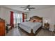Charming main bedroom featuring hardwood floors, curtains, and a large bed for optimal rest and relaxation at 16704 Sunburst Lake St, Wimauma, FL 33598