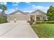 Charming single-story home with a three-car garage and well-manicured landscaping at 17731 Bright Wheat Dr, Lithia, FL 33547