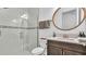Modern bathroom featuring a glass-enclosed shower, a round mirror, and a stylish vanity with countertop at 18017 Ramble On Way, Land O Lakes, FL 34638