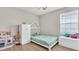 Bright bedroom features light wood floors, a house frame bed, and play kitchen set at 18017 Ramble On Way, Land O Lakes, FL 34638