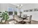 Bright dining room with large windows, modern light fixture, and wood floors at 18017 Ramble On Way, Land O Lakes, FL 34638