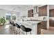 Open kitchen with quartz countertop island, breakfast bar, and stainless steel hood at 18017 Ramble On Way, Land O Lakes, FL 34638