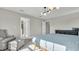 Bright main bedroom features three large windows, a gray rug, seating area, and dark dresser at 18017 Ramble On Way, Land O Lakes, FL 34638