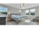 Bright main bedroom features three large windows, a gray rug, and a seating area at 18017 Ramble On Way, Land O Lakes, FL 34638
