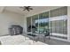 View of a modern patio with a grill, stylish seating, and sliding glass doors leading to the interior at 18017 Ramble On Way, Land O Lakes, FL 34638