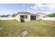 Wide view of backyard featuring a well-maintained lawn and screened patio at 18677 Milton Keynes Ct, Land O Lakes, FL 34638