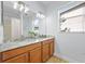 Bathroom featuring vanity with double sinks and large mirror at 18677 Milton Keynes Ct, Land O Lakes, FL 34638