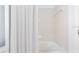 Clean bathroom features a tub with tile surround and white shower curtain at 18677 Milton Keynes Ct, Land O Lakes, FL 34638