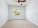 Bedroom featuring neutral walls, carpet, ceiling fan, and a bright window at 18677 Milton Keynes Ct, Land O Lakes, FL 34638