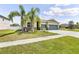 Attractive single-story home with a two-car garage, stone accents, palm trees, and well-manicured lawn at 18677 Milton Keynes Ct, Land O Lakes, FL 34638