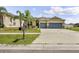 Charming single-story home featuring a spacious driveway and well-maintained front yard with palm trees at 18677 Milton Keynes Ct, Land O Lakes, FL 34638