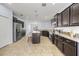 Spacious kitchen featuring stainless steel appliances, dark wood cabinets, granite countertops, and a convenient center island at 18677 Milton Keynes Ct, Land O Lakes, FL 34638