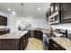 Close-up of kitchen island, granite countertops, and stainless steel appliances for a stylish culinary space at 18677 Milton Keynes Ct, Land O Lakes, FL 34638