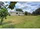Spacious backyard with healthy grass and the rear of the home with a new roof at 1980 Taylor Lake Cir, Largo, FL 33778