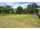 Expansive backyard offering ample space and a serene setting with lush greenery and shade trees at 1980 Taylor Lake Cir, Largo, FL 33778