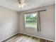 Bedroom with a large window offering a view of the outdoors, neutral walls, and wood-look flooring at 1980 Taylor Lake Cir, Largo, FL 33778