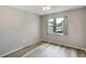 This is a bedroom with wood flooring, a window, and neutral paint at 1980 Taylor Lake Cir, Largo, FL 33778