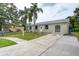 The home features a well-maintained lawn, an extra long driveway and a lovely, neat exterior at 1980 Taylor Lake Cir, Largo, FL 33778