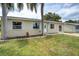 Inviting home exterior featuring a healthy green lawn, simple plantings and an updated entry door at 1980 Taylor Lake Cir, Largo, FL 33778