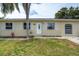 Charming single-story home with a well-maintained lawn, tidy landscaping, and neutral painted exterior at 1980 Taylor Lake Cir, Largo, FL 33778