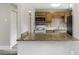 Well-lit kitchen featuring a counter bar, stainless steel appliances, stone countertops, and wood cabinets at 1980 Taylor Lake Cir, Largo, FL 33778
