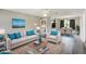 Staged living room featuring new flooring, modern furnishings, and an open view to the kitchen and dining areas at 1980 Taylor Lake Cir, Largo, FL 33778