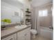 Bathroom with a white vanity, a framed mirror, a toilet, and a shower-tub combo with a neutral tile surround at 204 W Fern St, Tampa, FL 33604