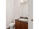 Neat half bathroom featuring a vanity with granite countertops and a framed mirror at 2130 W Spruce St, Tampa, FL 33607