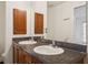 Bathroom featuring a double vanity with dark granite countertop and wooden cabinets at 2130 W Spruce St, Tampa, FL 33607