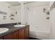 Bathroom featuring a vanity with dark granite countertop and wooden cabinets, a bathtub, and white tiles at 2130 W Spruce St, Tampa, FL 33607