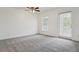 A spacious bedroom with a ceiling fan, window, and a door leading to a balcony at 2130 W Spruce St, Tampa, FL 33607