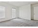 A light, carpeted bedroom with a window, door to the balcony, and closet at 2130 W Spruce St, Tampa, FL 33607