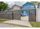 View of the house showing the driveway, garage, and the fenced in yard on a sunny day at 2130 W Spruce St, Tampa, FL 33607