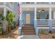 Inviting front porch features a ceiling fan, wood flooring, and views of lush greenery at 2130 W Spruce St, Tampa, FL 33607