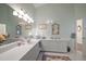 Spacious bathroom with double vanity, ample lighting, and elegant decorative mirrors at 2175 Oak Forest Ln, Palm Harbor, FL 34683