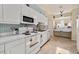 Well-lit kitchen boasts white cabinetry, modern appliances, and a pass-through to the dining area at 2175 Oak Forest Ln, Palm Harbor, FL 34683