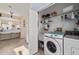 Convenient laundry room with modern washer, dryer, sink, and storage shelves at 2175 Oak Forest Ln, Palm Harbor, FL 34683