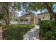 Community pool and covered lounge area surrounded by lush landscaping and a white fence at 2175 Oak Forest Ln, Palm Harbor, FL 34683