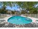 Relaxing community pool with sun loungers and a gazebo amidst lush greenery and white fencing at 2175 Oak Forest Ln, Palm Harbor, FL 34683