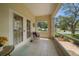 Cozy screened porch with neutral tones, tiled flooring, and a view of the neighborhood at 2175 Oak Forest Ln, Palm Harbor, FL 34683