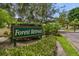 Entrance to Forest Retreat surrounded by lush greenery and well-maintained landscaping at 2175 Oak Forest Ln, Palm Harbor, FL 34683