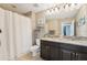 Bathroom with double granite vanity, dark cabinets and shower with curtain at 21834 Southern Charm Dr, Land O Lakes, FL 34637