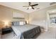 Bedroom with a window with view of the neighborhood, ceiling fan, and gray bedding at 21834 Southern Charm Dr, Land O Lakes, FL 34637