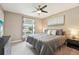 Bedroom with a window with view of the neighborhood, ceiling fan, and gray bedding at 21834 Southern Charm Dr, Land O Lakes, FL 34637