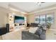 Comfortable living room boasts a custom entertainment center, tray ceiling, and large windows at 21834 Southern Charm Dr, Land O Lakes, FL 34637