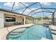 Sparkling screened pool with sun shelf, waterfall, and covered patio area at 21834 Southern Charm Dr, Land O Lakes, FL 34637