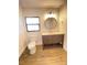 Bathroom with dark wood vanity, laminate flooring, and toilet under window, modern lighting at 2400 13Th S Ave, St Petersburg, FL 33712