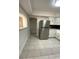 View of tiled kitchen floor, stainless steel refrigerator, and white cabinets with modern hardware at 2400 13Th S Ave, St Petersburg, FL 33712