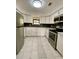 Bright, updated kitchen featuring stainless steel appliances, white cabinets, and sleek black backsplash and tiled floor at 2400 13Th S Ave, St Petersburg, FL 33712
